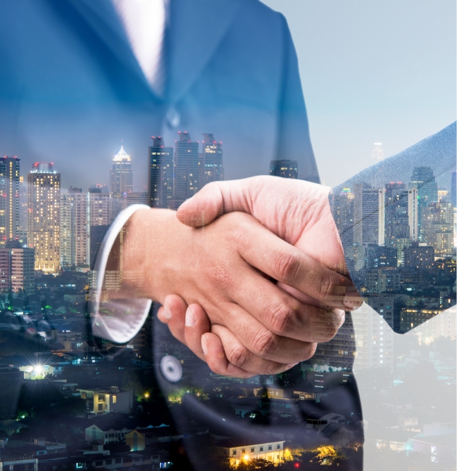A business handshake with a skyline in the background.